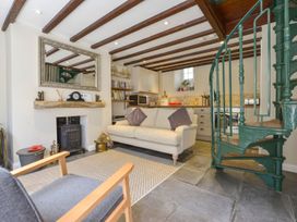 A living room with a sofa and stove at Woodedge in Minehead