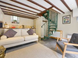 A living room with a sofa and staircase at Woodedge in Minehead
