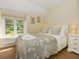 A bedroom with a bed and window at Woodedge in Minehead