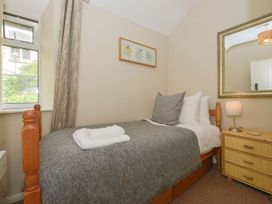 A bedroom with a bed and mirror at Woodedge in Minehead