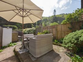 A garden seating area with an umbrella at Woodedge in Minehead