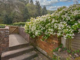 A garden area with flowers and a gate at Woodedge in Minehead