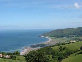 A beach along the coastline with hills and fields at Woodedge in Minehead