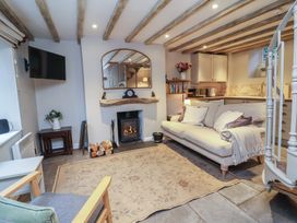 A living room with a fireplace and sofa at Woodedge in Porlock
