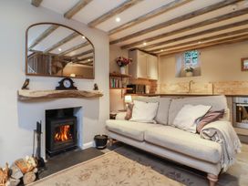 A living room with a fireplace and a sofa at Woodedge in Porlock