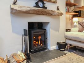 A living room with a fireplace and sofa at Woodedge in Porlock