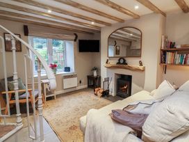 A living room with a sofa and a fireplace at Woodedge in Porlock
