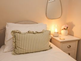 A bedroom with a bed and a bedside table at Woodedge in Porlock