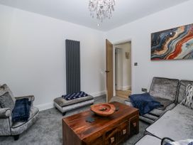 A living room with a coffee table and two sofas at Holy Trinity Cottage in Millom
