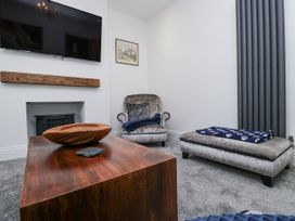 A living room with a sofa and television at Holy Trinity Cottage in Millom