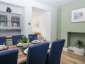 A dining room with a table set for a meal at Holy Trinity Cottage in Millom
