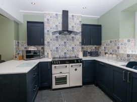 A kitchen with an oven and microwave at Holy Trinity Cottage in Millom