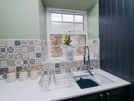 A kitchen with a sink and dish rack at Holy Trinity Cottage in Millom