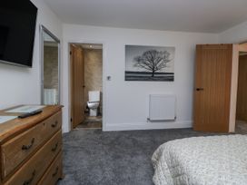 A bedroom with a bed and a television at Holy Trinity Cottage in Millom