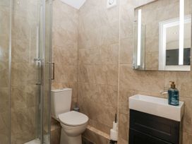 A bathroom with a shower, toilet, and sink at Holy Trinity Cottage in Millom