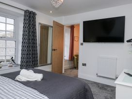 A bedroom with a television and mirror at Holy Trinity Cottage in Millom