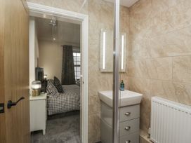 A bathroom featuring a shower, sink, and mirror at Holy Trinity Cottage in Millom