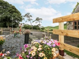 An outdoor area with flower pots and gravel at Holy Trinity Cottage in Millom