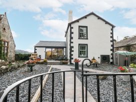 A house with a garden and flower pots at Holy Trinity Cottage in Millom