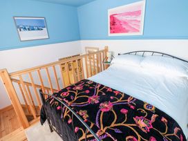 A bedroom with a bed and decorative wall art at No.51 Llanteg Park in Amroth