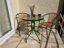 A balcony with a table and chairs at No.51 Llanteg Park in Amroth