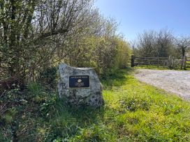 A sign indicating Lanteague Wood near a gate in Amroth