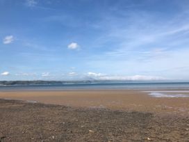 A beach with sand and ocean at No.51 Llanteg Park in Amroth