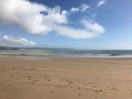 A beach with sand and ocean at No.51 Llanteg Park in Amroth