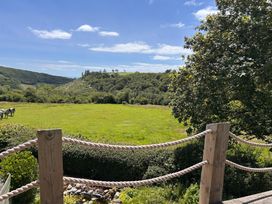 A scenic view of a grassy field with horses at 51 Llanteg Park in Amroth