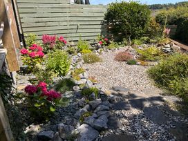 A garden with flowers and stones at 51 Llanteg Park Amroth