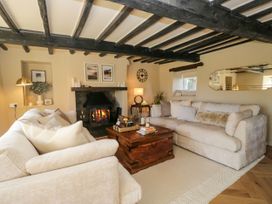 A living room with a fireplace and two sofas at Barn Howe Lyth near Levens
