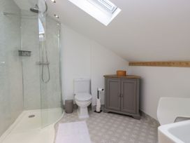 A bathroom with a shower, toilet, and cabinet at Barn Howe in Lyth near Levens