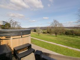 An outdoor area with a hot tub and view of trees and fields at Barn Howe Lyth near Levens