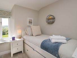 A bedroom with a bed and a lamp at Barn Howe in Lyth near Levens