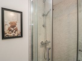 A shower with glass door and a picture on the wall at Barn Howe in Lyth near Levens