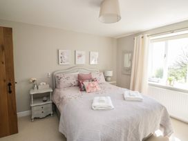 A bedroom with a bed, nightstand, and a window at Barn Howe Lyth near Levens
