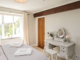 A bedroom with a bed and a vanity at Barn Howe in Lyth near Levens