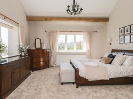 A bedroom with a bed, dresser, and window at Barn Howe in Lyth near Levens