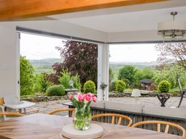 A living room with a table and flowers at Barn Howe in Lyth near Levens