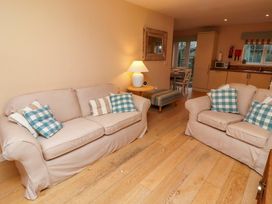 A living room with seating and kitchen area at High Sea View