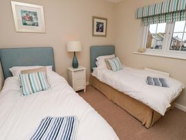 A bedroom with two single beds and a nightstand at High Sea View