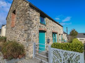 An exterior view of a stone building with teal doors at The Barn in Newport