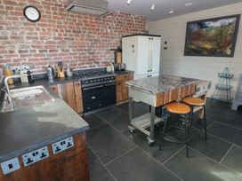 A kitchen with a stove, sink, and island at The Barn in Newport