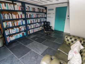 A reading room with bookshelves and a chair at The Barn in Newport