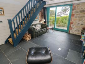 A living room with a sofa and staircase at The Barn in Newport