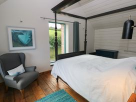 A bedroom with a bed and an armchair at The Barn in Newport