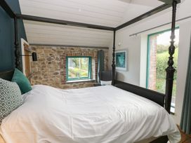 A bedroom with a bed and window at The Barn in Newport