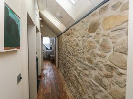 A hallway with a stone wall and wooden flooring at The Barn in Newport