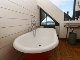 A bathroom with a bathtub and sink at The Barn in Newport