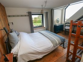 A bedroom with a bed and dressing table at The Barn in Newport